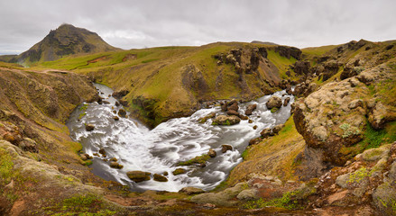 Panoramic view of Skogafoss waterfall on the Skoga river, a popular tourist attraction and part of the Golden Circle Tourist Route. Famous landmark of Iceland, Europe. Travelling concept background.