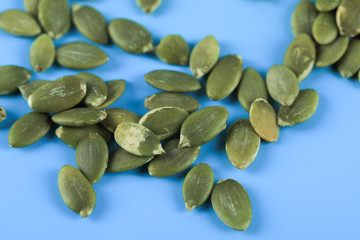 Green pumpkin seeds on a blue background