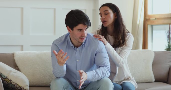 Young wife apologizing or supporting angry husband making peace after quarrel. Guilty worried girlfriend expressing comfort and apology talking to annoyed boyfriend trying to find compromise concept.