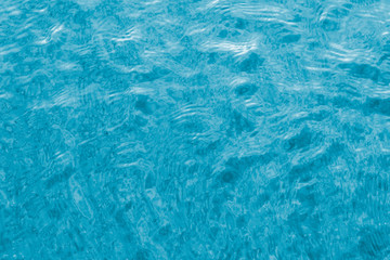 Bright blue water in the pool with ripples. Close-up shot for your inspirational design.