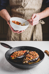 Preparing eggplants stuffed with ground beef, tomatoes and spices. Traditional dish Karniyarik of turkish cuisine