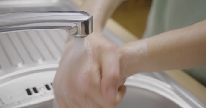 A woman washing her hands due to diseases, filmed from a high angle