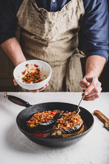 Preparing eggplants stuffed with ground beef, tomatoes and spices. Traditional dish Karniyarik of turkish cuisine