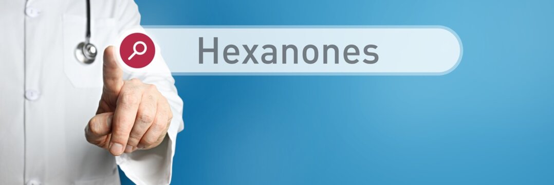 Hexanones. Doctor in smock points with his finger to a search box. The word Hexanones is in focus. Symbol for illness, health, medicine