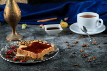 Bread toast with berry jam and a glass of tea