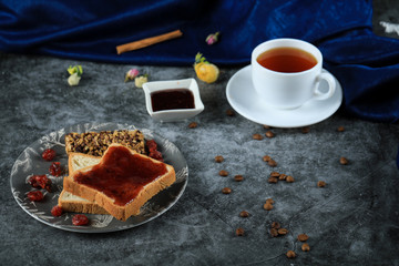 A cup of tea with chocolate toast and berry jam