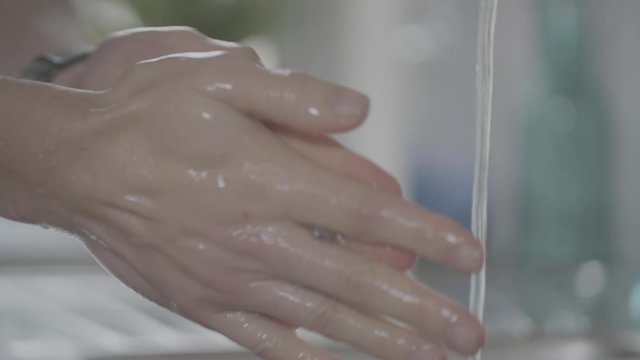 4k Washing hands close up with soap water and a rich lather of bubbles for good hygiene. Water running from a tap at home or office environment.