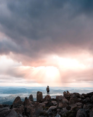 Man high mountain view over city during sunset