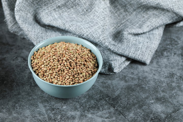 Green fresh and healthy lentil in a blue bowl in the center