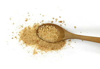 Ground biscuits in a wooden spoon on white background.
