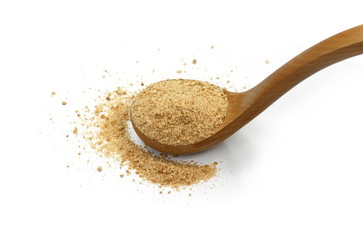 Ground biscuits in a wooden spoon on white background.