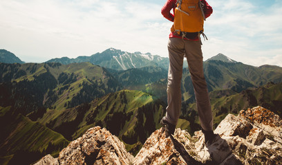 Strong woman hiker enjoy the view at cliff edge on mountain top