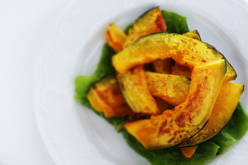 Pan fried pumpkin slices on white dish