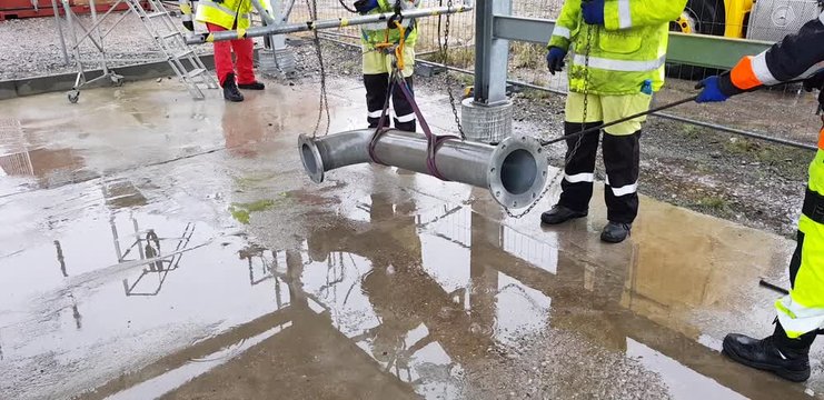 Riggers move the pipe using two chain blocks