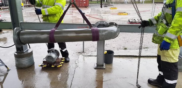 Riggers move the pipe using two chain blocks