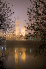 Church of our Lady of the Pillar in Zaragoza, Spain, illuminated at night with dense fog and reflections in the river