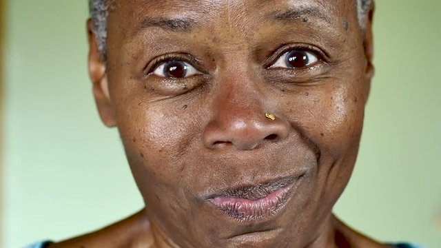 Pretty African American senior woman smirking with her mouth closed