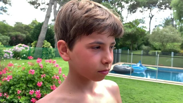 Young boy applies sunblock to face