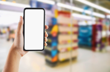 hand holding mobile white screen on  Supermarket store blur background