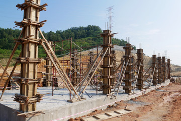 Fototapeta premium Column timber form work and reinforcement bar at the construction site. Installed by construction workers. The structure supported by temporary wood support.