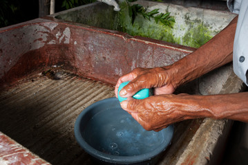 Coronavirus prevention, covid 19 in rural Guatemala, man washing hands, drinking water in El Progreso.