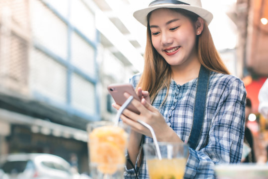 Young Asian Female Friends Taking Her Vacation And Eating Street Food  In Bangkok. Asian Woman Relax And Talking With Happiness Emotion.She Shoot Photo By Mobile Phone With Friend.