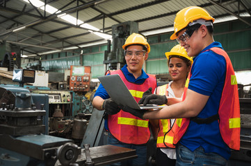 The industrial worker team is working on various projects in a large industrial factory with many...