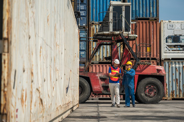 Foreman and dock worker staff working checking at Container cargo harbor holding clipboard. Business Logistics import export shipping concept.