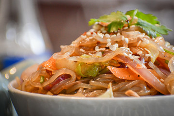 Sweet potato noodles fried with chicken and vegetables.