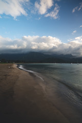 Beautiful Hawaii Beach in Kauai with Silky Waves during Warm Summer weather with thick clouds