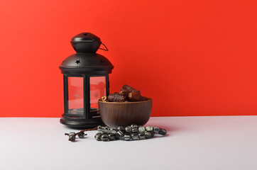 Lantern, dates fruit and rosary on red background. Islamic holidays concept.