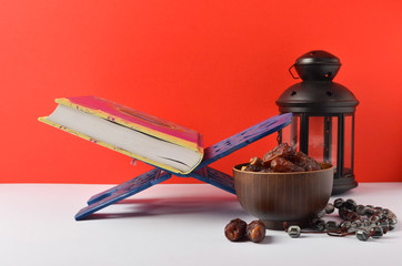 Lantern, dates fruit and rosary on red background. Islamic holidays concept.
