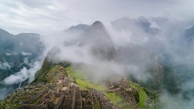 Time lapse view of mysterious Inca ruins of Machu Picchu shrouded in mist high in the Andes mountain range, Cusco Region, Peru.