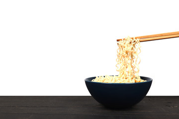 Instant noodles with chopsticks on wooden table isolated on whit