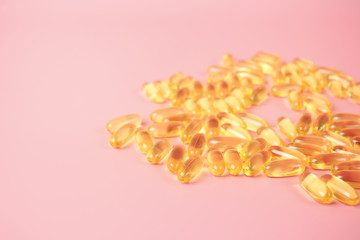 Omega-3 Rich Fish Oil Transparent Capsules Closeup Photo on pink background.