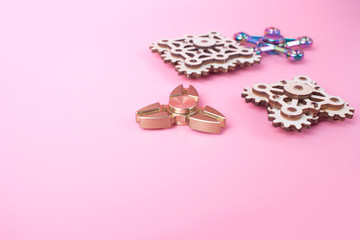 fidget finger spinners antistress, anxiety relief toy on pink background. spinners made different materials. Metal wooden.