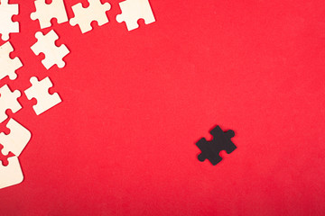 wooden white and black puzzles on a red background close-up top view. outcast antisocial leader...