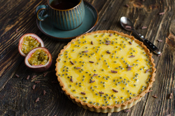 Homemade tart with chocolate and passion fruit flavor on dark wooden background