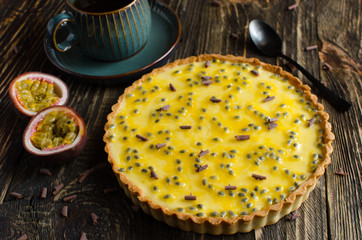 Homemade tart with chocolate and passion fruit flavor on dark wooden background