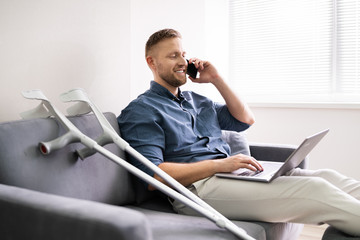 Man With Leg Injury Using Laptop