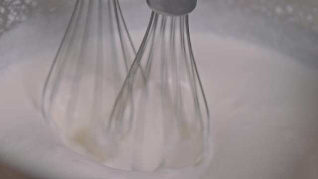 whisk in a bowl mixed cream low motion macro