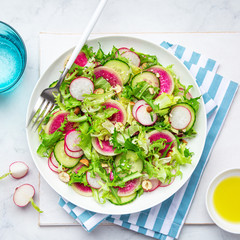 Fresh watermelon radish and  cucumber salad on white plate