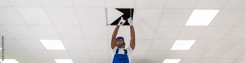 Wall mural electrician installing light on ceiling