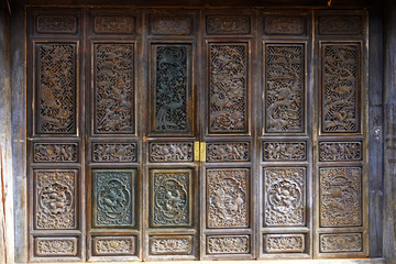 Fototapeta premium Beautiful wooden door with animal and floral carving at Lijiang, China. 
