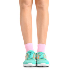 Legs of young woman in socks and shoes on white background