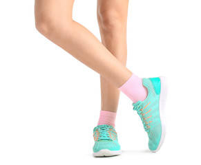 Legs of young woman in socks and shoes on white background