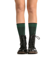 Legs of young woman in socks and shoes on white background