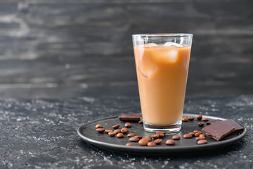 Glass of tasty iced coffee on dark background