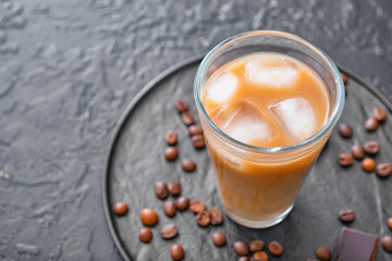 Glass of tasty iced coffee on dark background