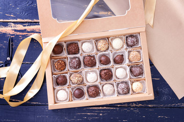 Box with delicious candies on dark wooden background
